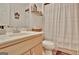 Bright bathroom featuring a modern vanity and shower with a decorative curtain and shelf at 676 Mcbride Rd, Fayetteville, GA 30215