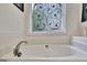 Elegant white bathtub featuring decorative ironwork on the window, offering a touch of sophistication at 676 Mcbride Rd, Fayetteville, GA 30215