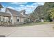 Home exterior with stone accents, a porch, and a long driveway leading to ample parking; beautiful landscaping at 676 Mcbride Rd, Fayetteville, GA 30215