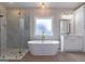 Luxurious bathroom featuring a standalone tub, glass shower, and modern fixtures at 4080 Whitney Rd, Social Circle, GA 30025