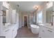 Elegant bathroom with double vanities, a standalone tub, and a glass-enclosed shower at 4080 Whitney Rd, Social Circle, GA 30025
