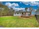 Spacious backyard featuring green grass, mature trees, a deck, and a secure fence at 1910 Reese Rd, Rutledge, GA 30663
