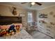 A well-lit bedroom with a rustic headboard, play kitchen and a cozy interior design at 1910 Reese Rd, Rutledge, GA 30663