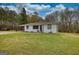 Charming home featuring white brick, black trim, lovely lawn, and covered parking at 1910 Reese Rd, Rutledge, GA 30663