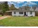 Charming home featuring white brick, black trim, lovely lawn, and covered parking at 1910 Reese Rd, Rutledge, GA 30663