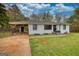 Charming home featuring white brick, black trim, lovely lawn, and covered parking at 1910 Reese Rd, Rutledge, GA 30663