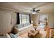 Cozy living room boasts hardwood floors, large windows, ceiling fan, and comfortable furniture at 1910 Reese Rd, Rutledge, GA 30663