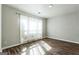 Bright bedroom boasts gleaming hardwood floors and a large window with sheer curtains at 4180 Pineset Dr, Alpharetta, GA 30022