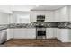 Well-lit kitchen with white cabinetry, modern appliances, and stone backsplash, perfect for cooking at 4180 Pineset Dr, Alpharetta, GA 30022