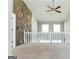 Open loft space with a stone accent wall, white railings, and great natural light at 4180 Pineset Dr, Alpharetta, GA 30022