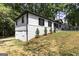 Side view of a home showcasing its white siding, brick foundation, and tree-lined surroundings at 2145 Venesa Cir, Austell, GA 30168