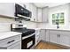 Updated kitchen featuring stainless steel appliances, gray cabinets, light countertops, and hardwood flooring at 2145 Venesa Cir, Austell, GA 30168