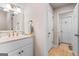 White bathroom with a single sink vanity, beige walls, a framed mirror, and tile floors at 2173 Conyers Se St, Covington, GA 30014