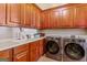 Functional laundry room with built-in cabinets, a utility sink, and modern washer and dryer units at 2173 Conyers Se St, Covington, GA 30014