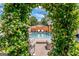 Inviting pool and patio area viewed through a lush floral arch, creating a tranquil and picturesque scene at 2173 Conyers Se St, Covington, GA 30014