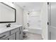 Bathroom featuring a gray vanity, toilet, shower and tub combo with black hardware at 279 Deer Creek Run # 4, Moreland, GA 30259