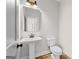 Compact half bathroom with pedestal sink, mirror, and toilet, ideal for guests at 279 Deer Creek Run # 4, Moreland, GA 30259