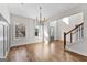 Open-concept dining area with hardwood floors, a chandelier, and natural light, flowing into the foyer and staircase at 279 Deer Creek Run # 4, Moreland, GA 30259