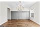 Elegant dining room featuring a modern chandelier, wainscoting, hardwood floors, and natural light from the window at 279 Deer Creek Run # 4, Moreland, GA 30259