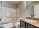 Full bathroom with tub, white tile surround, and granite topped vanity at 5599 Fair Creek Way, Lithonia, GA 30038