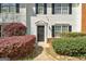 Close-up showcasing the front of a well-kept townhome with black shutters and green landscaping at 5599 Fair Creek Way, Lithonia, GA 30038