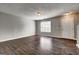 Large living area featuring dark hardwood floors, a window, and a well-lit entry door at 5599 Fair Creek Way, Lithonia, GA 30038