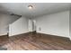 Open-concept living area with hardwood flooring, neutral paint, and staircase access at 5599 Fair Creek Way, Lithonia, GA 30038