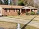Charming brick home featuring a well-maintained lawn, cozy front porch, and classic red shutters at 2140 Indian Hill Rd, Jonesboro, GA 30236