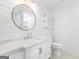 Bright bathroom features white shiplap, round mirror, marble countertops, and white vanity at 1190 N Ola Rd, Mcdonough, GA 30252