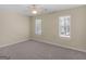 This bedroom features neutral carpet, two bright windows with blinds, and a ceiling fan at 1190 N Ola Rd, Mcdonough, GA 30252