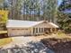 Charming ranch-style home featuring a metal roof, attached garage, and a well-manicured front yard at 1190 N Ola Rd, Mcdonough, GA 30252