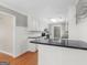 Bright kitchen featuring white cabinets, black countertops, stainless steel appliances, and hardwood floors at 1190 N Ola Rd, Mcdonough, GA 30252