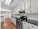 Bright kitchen features white cabinetry, stainless steel appliances, stone countertops, and hardwood floors at 1190 N Ola Rd, Mcdonough, GA 30252
