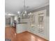 Open-concept kitchen featuring hardwood floors, a modern chandelier, and French doors to the backyard at 1190 N Ola Rd, Mcdonough, GA 30252