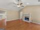 Bright living room with a fireplace, hardwood floors, and ceiling fan at 1190 N Ola Rd, Mcdonough, GA 30252