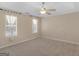 Main bedroom offers neutral carpet, two bright windows, and a ceiling fan at 1190 N Ola Rd, Mcdonough, GA 30252