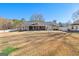 Wide view of the home from the backyard, displaying the extensive lawn, screened porch, and overall property layout at 90 Hazelridge Ln, Sharpsburg, GA 30277