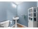 A cozy half-bathroom featuring a modern sink, toilet, and built-in shelves at 90 Hazelridge Ln, Sharpsburg, GA 30277