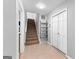 Bright hallway featuring carpeted stairs, convenient closet storage, and neutral tones at 90 Hazelridge Ln, Sharpsburg, GA 30277