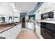 Well-lit kitchen showcasing granite countertops, white cabinetry, stainless steel appliances, and a skylight at 90 Hazelridge Ln, Sharpsburg, GA 30277