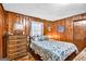 Comfortable bedroom featuring wood paneling, dresser and bright window at 100 Cross Plains Hulett Rd, Carrollton, GA 30116
