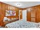 Cozy bedroom features wood paneled walls, dresser, bed and closet at 100 Cross Plains Hulett Rd, Carrollton, GA 30116