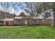 Charming brick home featuring a metal roof, shutters, and a lush green lawn at 100 Cross Plains Hulett Rd, Carrollton, GA 30116
