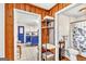 Inviting hallway with wood paneling, leading to a kitchen with blue cabinets and a bathroom at 100 Cross Plains Hulett Rd, Carrollton, GA 30116