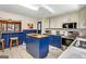 Well-lit kitchen with blue lower cabinets, white upper cabinets and view of the living room at 100 Cross Plains Hulett Rd, Carrollton, GA 30116