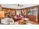 Cozy living room with wood-paneled walls, hardwood floors, and a comfortable red leather sofa at 100 Cross Plains Hulett Rd, Carrollton, GA 30116