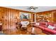 Comfortable living room featuring a brick fireplace, wood paneling, and classic furniture at 100 Cross Plains Hulett Rd, Carrollton, GA 30116