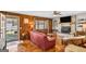Living room with wood-paneled walls, brick fireplace, and a cozy red leather sofa at 100 Cross Plains Hulett Rd, Carrollton, GA 30116