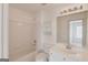 This bright bathroom offers a bathtub, toilet, sink, vanity, mirror, and storage cabinet at 5808 Deer Crossing Dr, Sugar Hill, GA 30518
