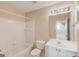 Bathroom featuring a toilet, sink, mirror, vanity, cabinet, shower, and tiled wall at 5808 Deer Crossing Dr, Sugar Hill, GA 30518